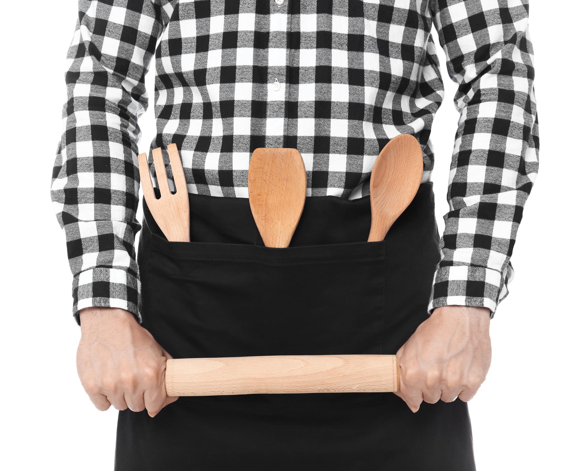 Chef al lavoro su un piano di legno con utensili